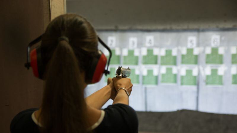 woman aiming a gun at a shooting target